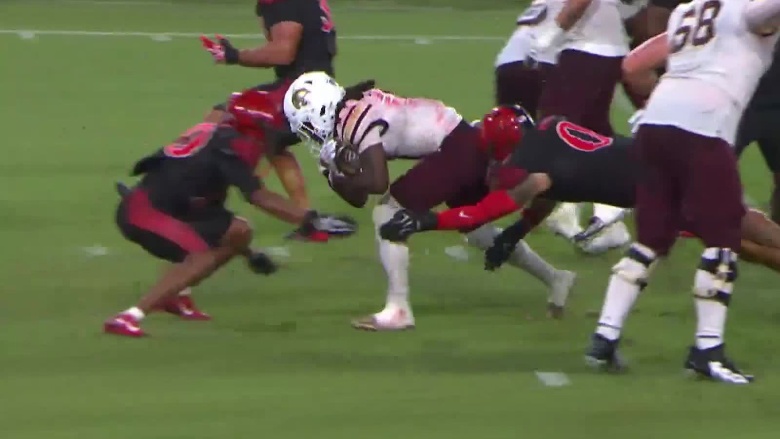 A Texas State running back drives through two San Diego State tacklers